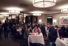 Haute Cuisine A busy upscale restaurant renowned for its haute cuisine, with people dressed in formal attire dining at tables covered with white tablecloths. The lively atmosphere features modern lighting, wall art, and attentive waitstaff serving guests throughout the elegant space.