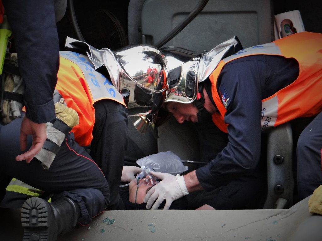 Sapeurs pompiers providing medical assistance to injured man