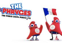 Mascotte des Jeux Olympiques de Paris 2004 Les Phryges Deux mascottes rouges, douces et triangulaires appelées "Les Phryges" se tiennent ensemble. L'une des mascottes tient un drapeau français et a une prothèse de jambe. Toutes deux portent des baskets et des badges olympiques de Paris 2024. La mention "LES PHRYGES MASCOTES OLYMPIQUES PARIS 2024" apparaît au-dessus d'eux en caractères gras.