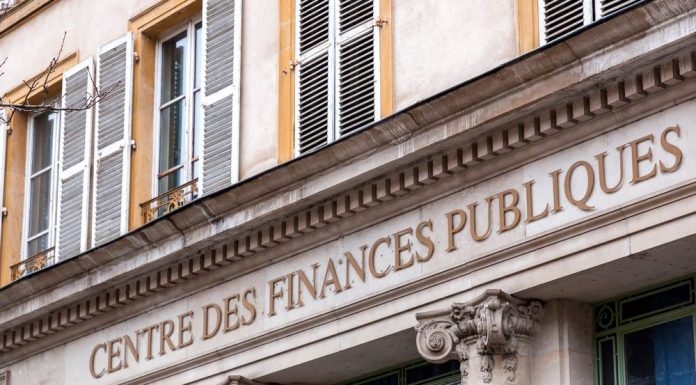 French property owners mandatory declaration A stone building facade with large letters reading “CENTRE DES FINANCES PUBLIQUES” signifies where French property owners fulfill their mandatory declaration, featuring ornate columns and windows with open white shutters above. The architecture is classical and viewed from below.