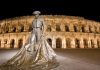 Guide Touristique de Nîmes Bullfighter statue in front of Nîmes Arena at night
