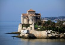 Talmont-sur-Gironde: The Flower-Filled Bastide of the Gironde The church at Talmont on the sea wall seen from a distance jutting out into Gironde Estuary