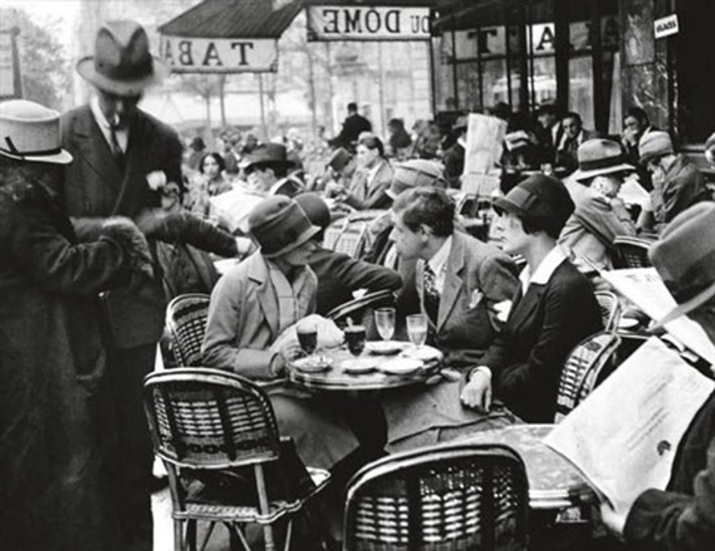 Black and white photo of a very busy outdoor Parisian café